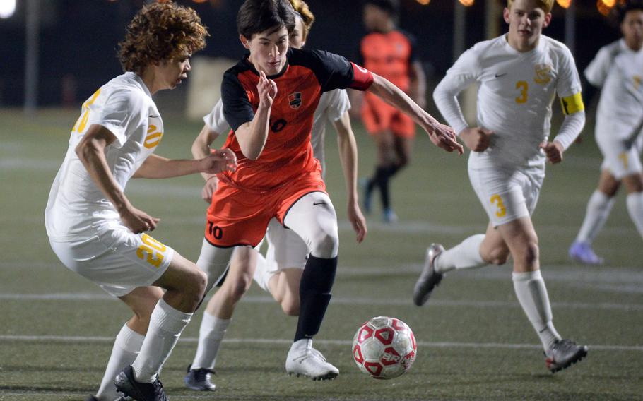 Nile C. Kinnick's Ryo Nishiyama dribbles between Yokota's Justice Schneck and Caleb Jones during Friday's DODEA-Japan soccer match. The Red Devils won 3-0.