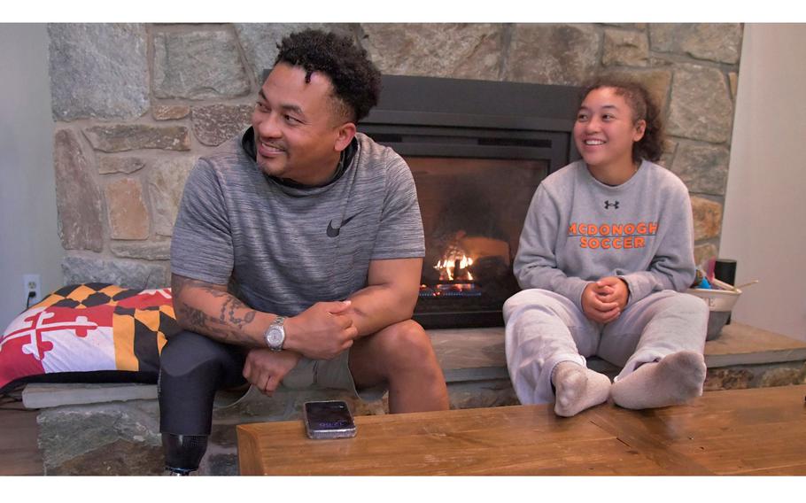 Jae Terry, left, watches football at home on the weekend with his daughter, Lexi, a junior center back for the top-ranked McDonogh girls soccer team. Lexi gets inspiration from her father, a Navy veteran who lost his leg as a result of combat in Afghanistan. 