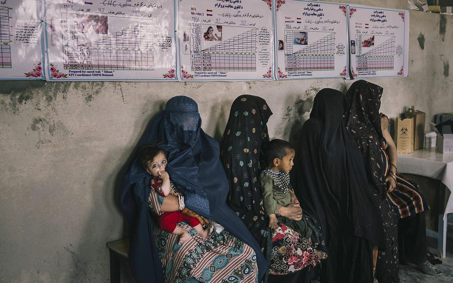 Patients wait in line to be seen by a doctor at a clinic in Sangin, on June 15, 2022.