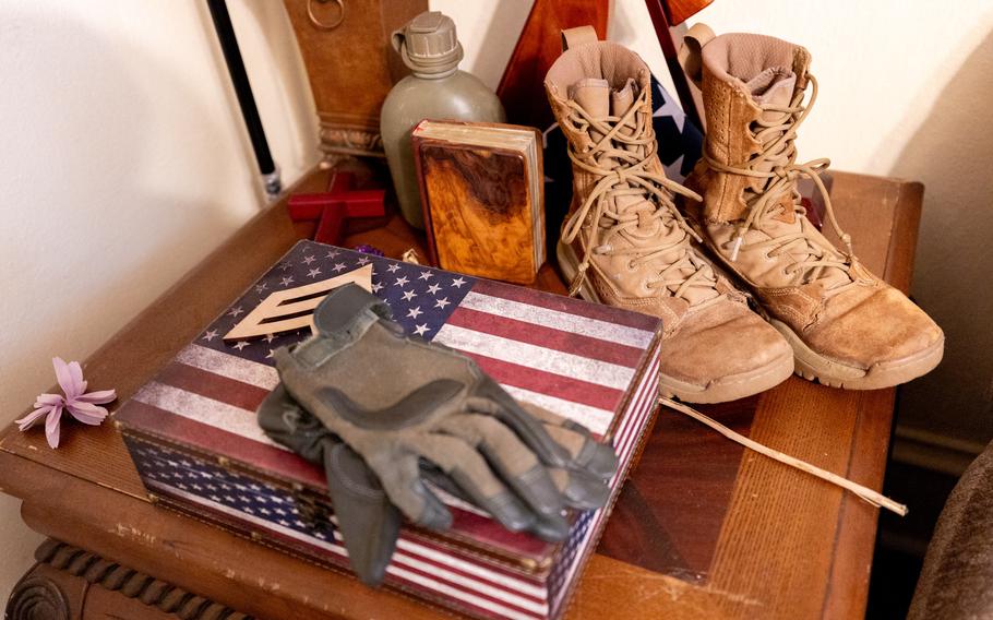 Gloves and Army boots on a small table or cabinet.