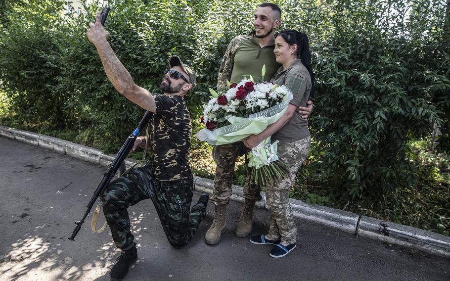 Natalia Tkachenko, 32, and Mykola Kovtun, as they pose for a photograph during their engagement celebration at a hospital in the eastern Ukrainian city of Sloviansk on June 30, 2022. Tkachenko works as a military nurse and her fiancé just came from the front lines to propose marriage to her. 