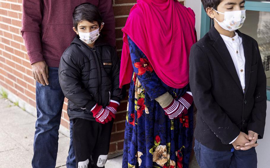 Mirwais, 7, left, and his family wait outside their new school, Southern Heights Elementary, where they will take a tour of the grounds and classes, on Wednesday, Feb. 16, 2022 in Burien, Washington.