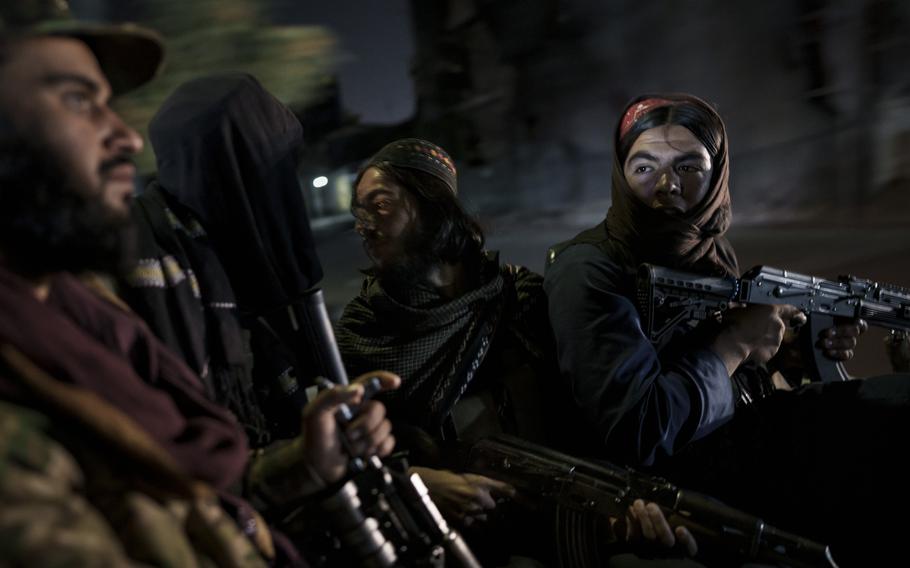 Taliban fighters ride in the back of a vehicle during a night patrol in Kabul, Afghanistan, on Sept. 12, 2021. 