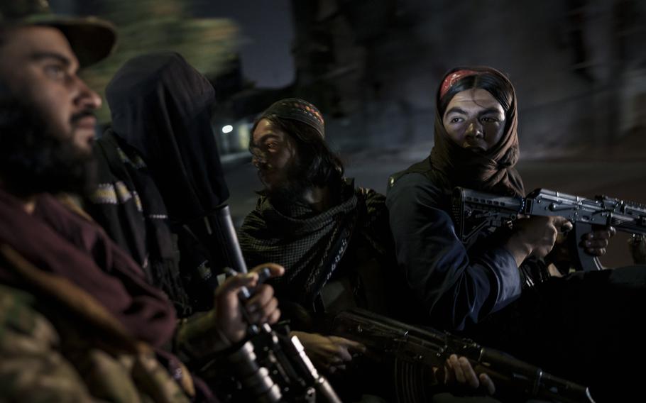 Taliban fighters ride in the back of a vehicle during a night patrol in Kabul, Afghanistan, on Sept. 12, 2021.