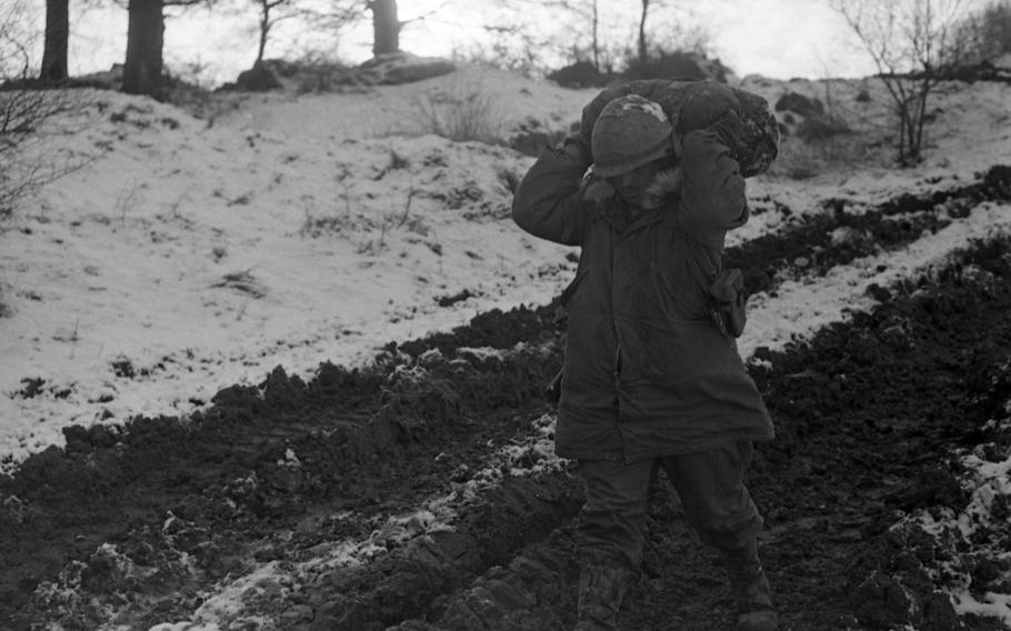 Unidentified soldier walks through the dirt-tracks made by the many Army tanks and jeeps that preceded him. “Blue Forces” battled “Orange Forces” in the Grafenwoehr - Vilseck area during the multi-day Carbide Ice exercise, part of Reforger I. Both 24th and 19th Infantry Division took part in the “battle.”