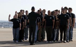 New Air Force recruits are sworn in by Maj. Jake Hall on April 12, 2025, during an air show at March Air Reserve Base, Calif. The number of Air Force and Space Force recruits eligible for initial enlistment bonuses is projected to rise fivefold in 2026, both services say in budget documents.