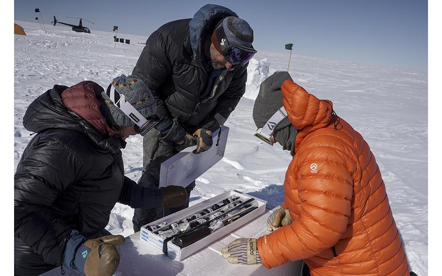 Jason Briner, center, shows core samples from the Winkie drill camp to Balter-Kennedy, left, and Schaefer. 