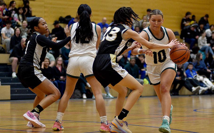 Naples sophomore Gracie Grannis tries to dribble through Vicenza sophomore Tishauna Lewis in pool-play action of the DODEA European Basketball Championships on Feb. 15, 2024, at Wiesbaden High School in Wiesbaden, Germany.