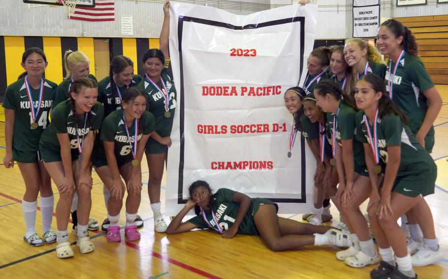 Banner time! Kubasaki's girls soccer team gathers 'round the Division I spoils.