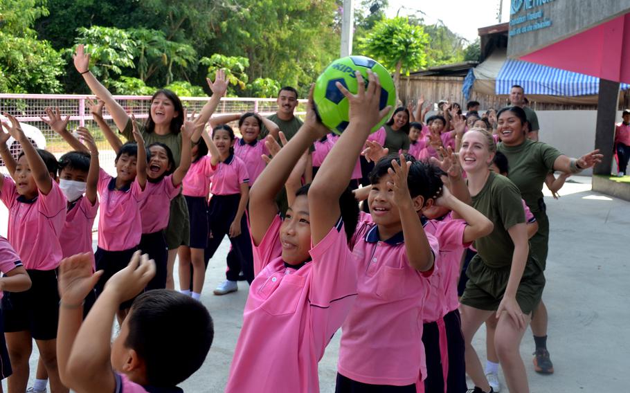 U.S. Marines pass a soccer ball with children at a day care in Pattaya, Thailand, March 6, 2024.