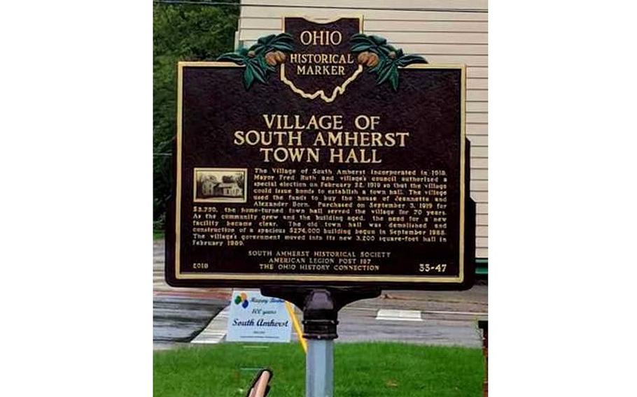 A vertical photo of a brown plaque noting a historic site.
