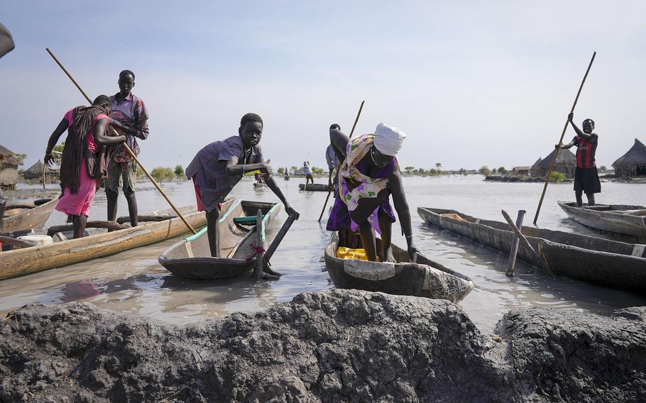Residents park their dugout canoes next to a mud dyke they built to try and prevent flooding, in New Fangak town in Jonglei state, South Sudan Monday, Dec. 25, 2021.