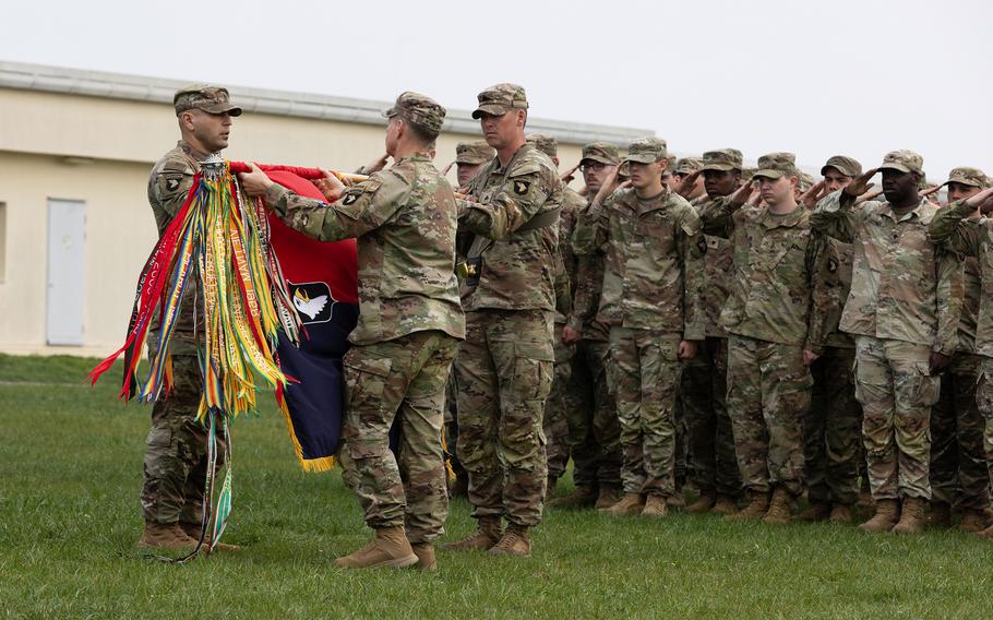 Army Col. Duke Reim, center, and Command Sgt. Maj. Angelo Fazio, left, the command team for 2nd Brigade, 101st Airborne Division, uncase the unit’s colors during a transfer of authority ceremony March 26, 2025, at Mihail Kogalniceanu Air Base, Romania.