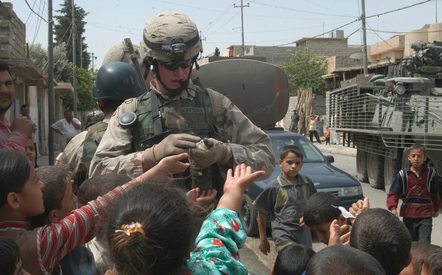 U.S. soldiers score big with the Iraqi children of the Isla Zeral neighborhood of Mosul in 2005, as the kids call out for candy or soccer balls.