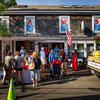 The exterior of the Wharf Pub in Martha’s Vineyard is seen with people in front of it during a “Jaws” 50th annivesary event. Each of the windows of the pub has a different letter of the word “Jaws.”