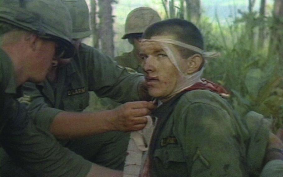 A wounded soldier of the 1st Battalion, 7th Cavalry, is attended to by fellow comrades during the fight for LZ X-Ray in the Ia Drang Valley of Vietnam. Photo extracted from U.S. Army motion picture footage from November 1965.