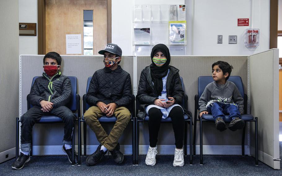 The Qanit children, from left: Abdul Ahad, 11, Abdul Qadeer, 14, Aysha, 14, and Yosuf, 6, wait while their parents register them for public school.