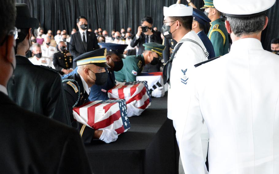 Members of a South Korean-American honor guard lift boxes holding the remains of service members killed in the Korean War during a repatriation ceremony at Joint Base Pearl Harbor-Hickam, Hawaii, Wednesday, Sept. 22, 2021.