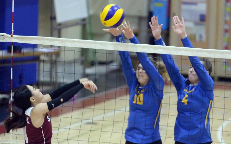 Seisen's Maya Hemmi tries to hit through the double block of Yokota's Lucy Wellons and Makayla Clouse during Tuesday's Kanto Plain volleyball match. The host Phoenix won in three sets.