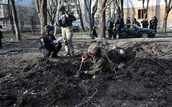 Ukrainian explosive technicians examine the site of the explosion after a missile strike in Kharkiv on April 6, 2024, amid the Russian invasion in Ukraine. A Russian night-time attack on Ukraine's second city of Kharkiv killed six people and wounded at least 11, the local prosecutor's office said on social media, on April 6, 2024. (Sergey Bobok/AFP via Getty Images/TNS)