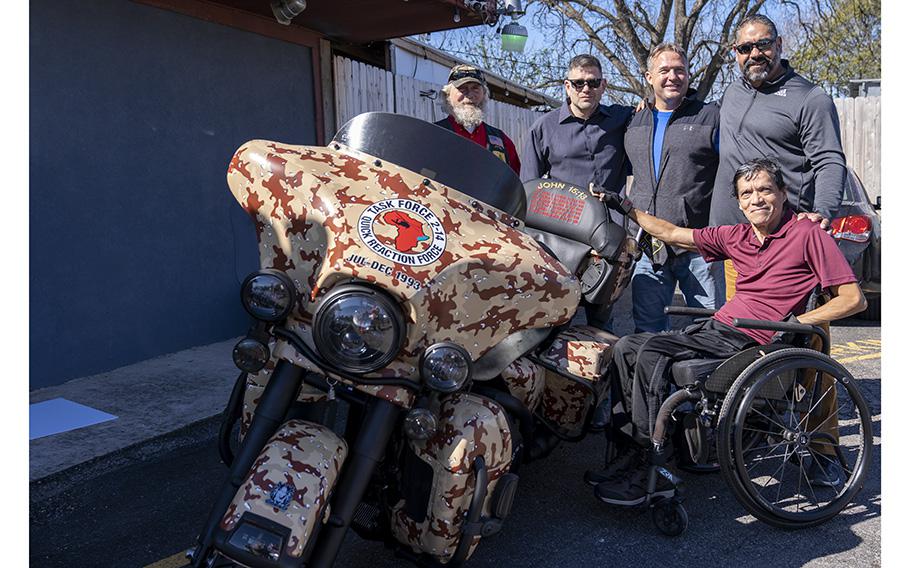 Veterans of the 1993 Battle of Mogadishu, Somalia, pose with a specially reconstructed Harley Davidson motorcycle, named “Forgotten Bastards”, as a tribute to remember those who fought, and lost their lives during the battle. 