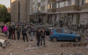 Residents gather at the site where an apartment building was hit during Russian drone attacks on May 30, 2023, in Kyiv, Ukraine. The capital Kyiv got under a third Russian air attack in 24 hours. At least one person was killed in an early Tuesday strike, the Kyiv mayor said. (Roman Pilipey/Getty Images/TNS)