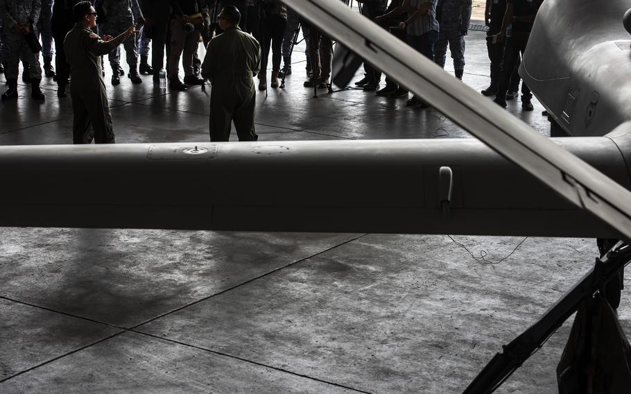 Capt. Tim Nolan, left, and Capt. Angelo Tapalla, unmanned aerial vehicle pilots with the California Air National Guard, brief Philippine navy sailors about the MQ-9 Reaper at the former home of Naval Air Station Cubi Point, Philippines, Sunday, April 23, 2023.