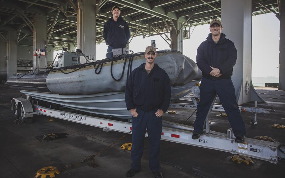 Boatswain’s Mate 2nd Class Adam McGreevy, left, Chief Boatswain’s Mate Erick Chavez, center, and Seaman Michael Burkus, right, pose for a photo on a rigid-hull inflatable boat aboard the Expeditionary Sea Base USS Lewis B. Puller (ESB 3) Jan. 5.