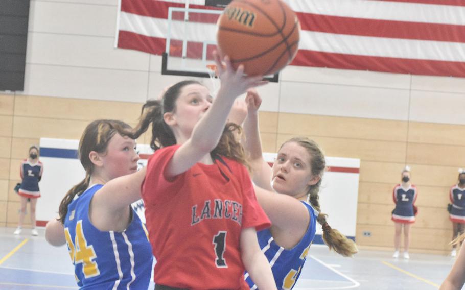 Lakenheath sophomore Jessie Moon splits a pair of Wiesbaden defenders to attack the basket on Thursday, Feb. 24, 2022, at the DODEA-Europe basketball championships.