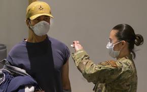 Tech. Sgt. Hazel Mangabat, 88th Healthcare Operations Squadron, injects Dr. Octavio Borges, a contractor with the U.S. Air Force School of Aerospace Medicine, with the COVID-19 vaccine Jan. 8, 2021, on Wright-Patterson Air Force Base, Ohio. 