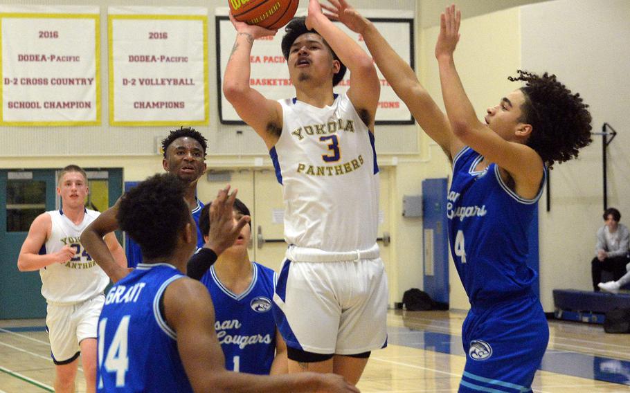 Yokota's Dylan Tomas shoots between Osan defenders Jaylon Grant, A.J. Panboon and Travus Boyd during Wednesday's boys D-II final.