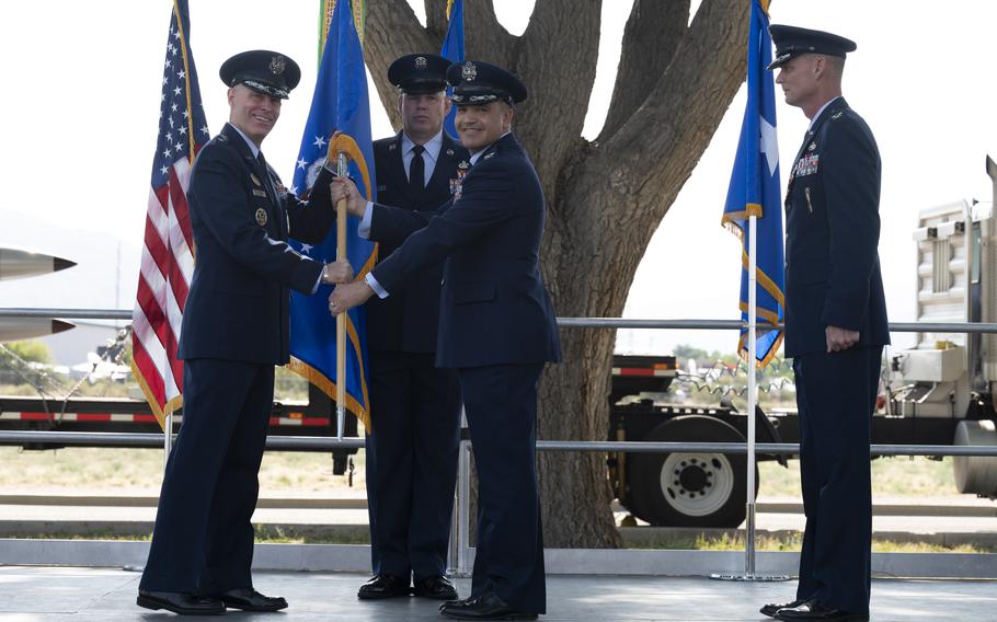 U.S. Air Force Maj. Gen. Michael J. Lutton, left, 20th Air Force commander, passes the guidon to incoming commander Col. Jason F. Vattioni, right, at Kirtland Air Force Base, New Mexico, June 22, 2021.  Vattioni assumed command of the 377th Air Base Wing as the installation commander.