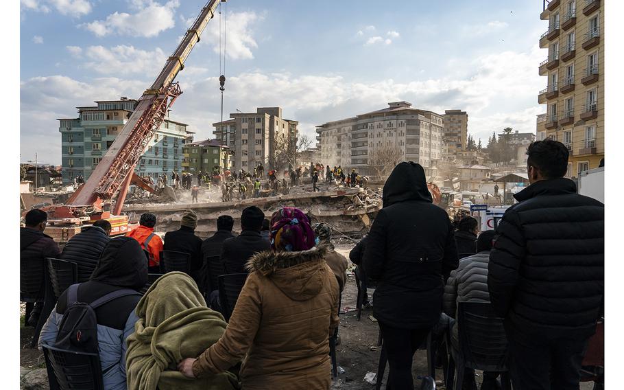Relatives watch as rescue teams and members of the Turkish military look for earthquake survivors in Islahiye, Turkey, on Feb. 11, 2023. 