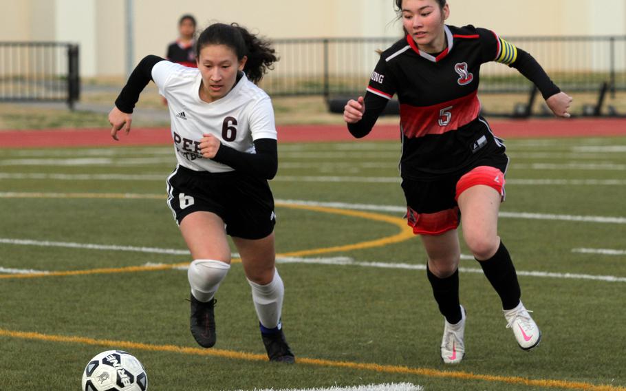 Matthew C. Perry's Sasha Malone and E.J. King's Aileen FitzGerald chase down the ball during Friday's DODEA-Japan girls soccer season opener at Samurai Field. The Cobras won 1-0.