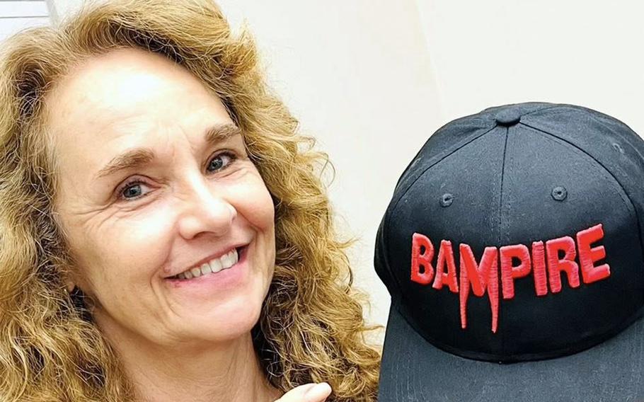 Actor Diane Franklin holds up a “Bampire” movie baseball hat. 