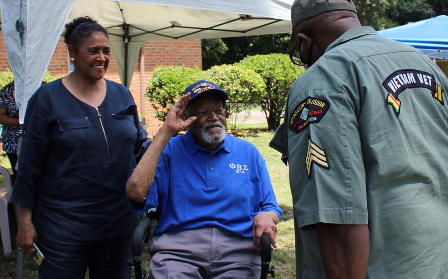 Retired Lt. Col. Louis Frazier Martin and Sgt. Albert W. Cooks salute during Martin's 104 birthday celebration in Chesterfield, Va. on July, 3, 2021. Also pictured is Martin's daughter Sheila Martin Brown.