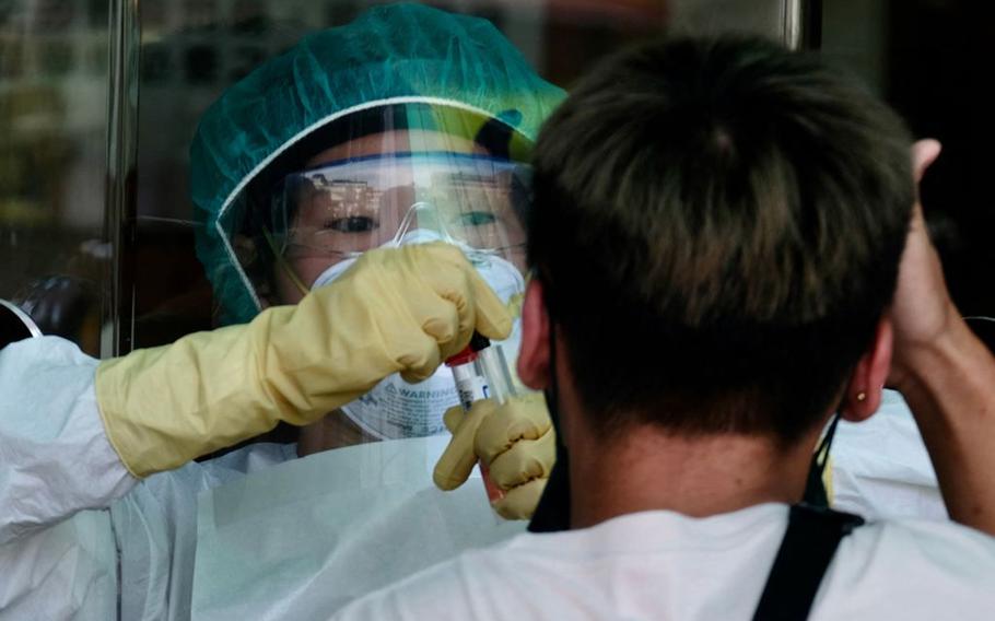 A medical staffer collects a sample from a local resident during a COVID-19 corona virus testing at the Xindian District in New Taipei City on May 21, 2021. 