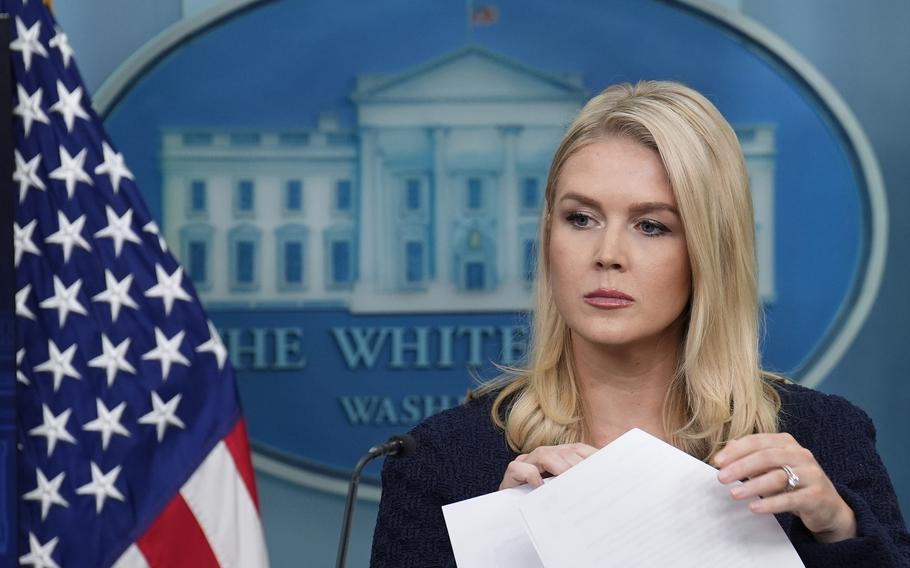 White House press secretary Karoline Leavitt turns a page at a podium.