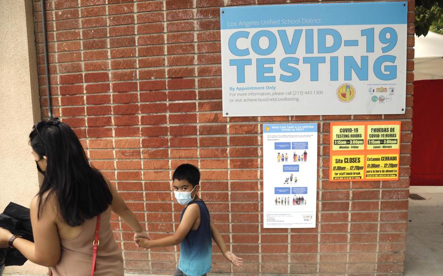 Skyzell Touch, 6, is pulled along by his mother Raizah Touch as the first grader goes to be tested for COVID-19 before he begins to attend classes on Monday at Northridge Middle School in Northridge, Calif., on Aug. 11, 2021.  LAUSD has the most robust COVID-19 testing protocol in California, requiring all students and teachers to be tested weekly. 