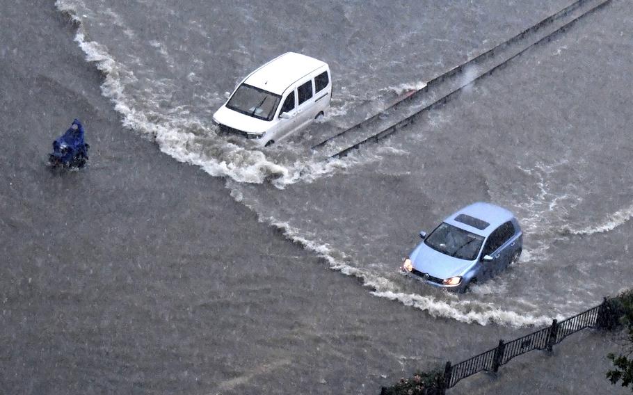 In this photo released by Xinhua News Agency, vehicles pass through floodwaters in Zhengzhou in central China's Henan Province on Tuesday, July 20, 2021. At least a dozen people died in severe flooding Tuesday in a Chinese provincial capital that trapped people in subways and schools, washed away vehicles and stranded people in their workplaces overnight. 