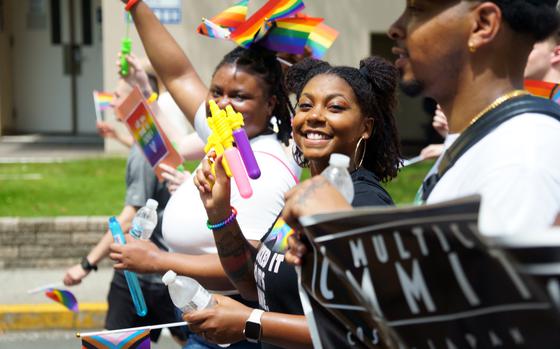 People wave rainbow flags and shout "Happy Pride!" during a Pride Day parade at Yokosuka Naval Base, Japan, Wednesday, June 28, 2023. 