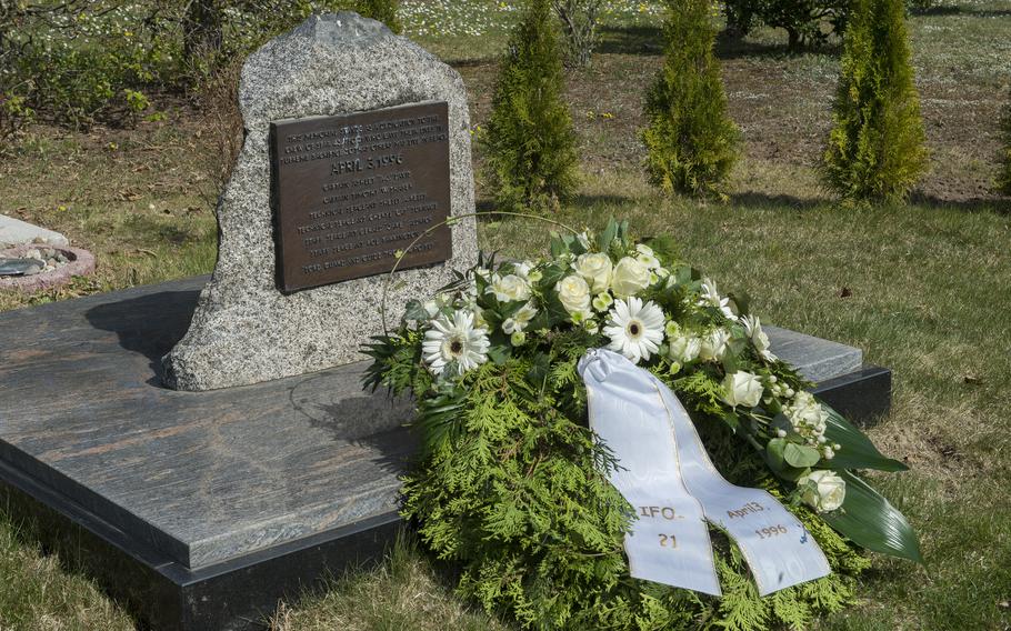 A wreath with a white ribbon rests at a memorial