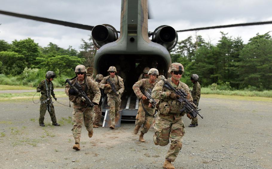 U.S. soldiers sprint off a Japan Ground Self-Defense Force helicopter during air-assault training at Aibano Training Area, Japan, during Orient Shield drills, July 1, 2021. 