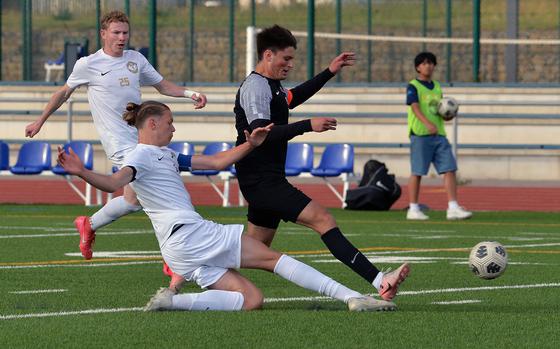 Kelan Vaughn of Ramstein slides in to separate Stuttgart’s Seth Harpuder from the ball in the Division I boys final at the DODEA-Europe soccer championships in Ramstein, Germany, May 22, 2025. Ramstein took the title with a 2-0 win.