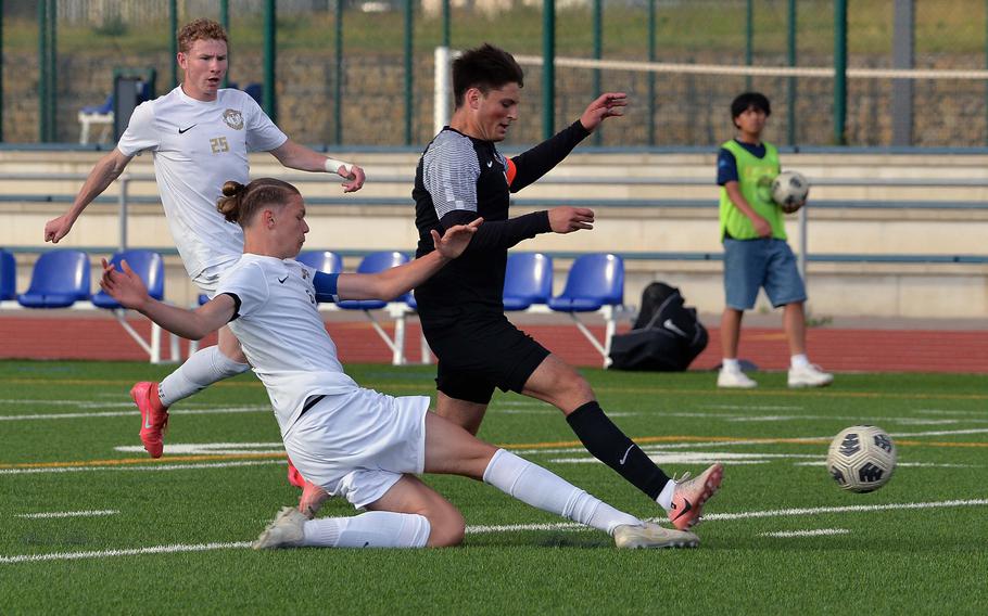 Kelan Vaughn of Ramstein slides in to separate Stuttgart’s Seth Harpuder from the ball in the Division I boys final at the DODEA-Europe soccer championships in Ramstein, Germany, May 22, 2025. Ramstein took the title with a 2-0 win.