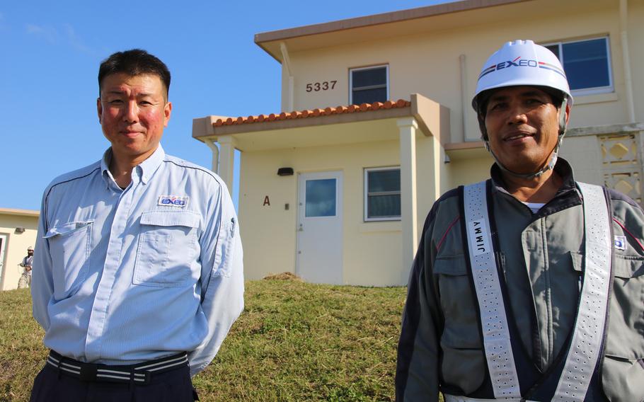 Japanese contractors Takashi Kobayashi, left, and Jimmy Belarma Mitra of Tokyo-based Exeo Group Inc. pause during work at a two-story duplex on Kadena Air Base on Dec. 14.