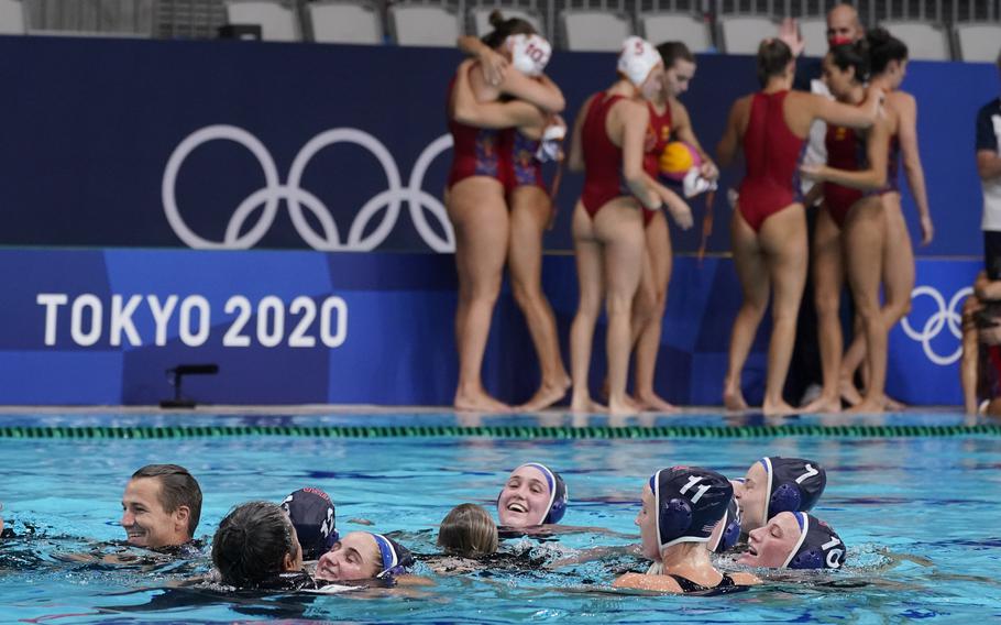 The United States women's water polo team celebrates in the pool as Spain's players console one another in the background after the gold medal match at the 2020 Summer Olympics, Saturday, Aug. 7, 2021, in Tokyo, Japan. 