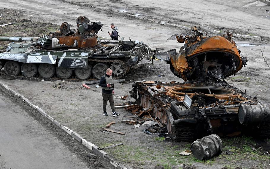 Residents look at a destroyed Russian tank on the outskirts of Buzova village, west of Kyiv, Ukraine, on April 10, 2022. (Sergei Supinsky/AFP/Getty Images/TNS)