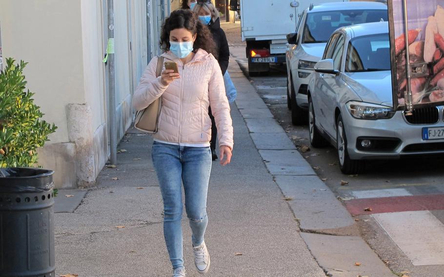 A woman wears a mask while walking a Vicenza, Italy, street in 2020. On Nov. 29, 2021, the Italian news agency Ansa reported that Italy was considering mandatory mask wearing outdoors nationwide beginning Dec. 6. 