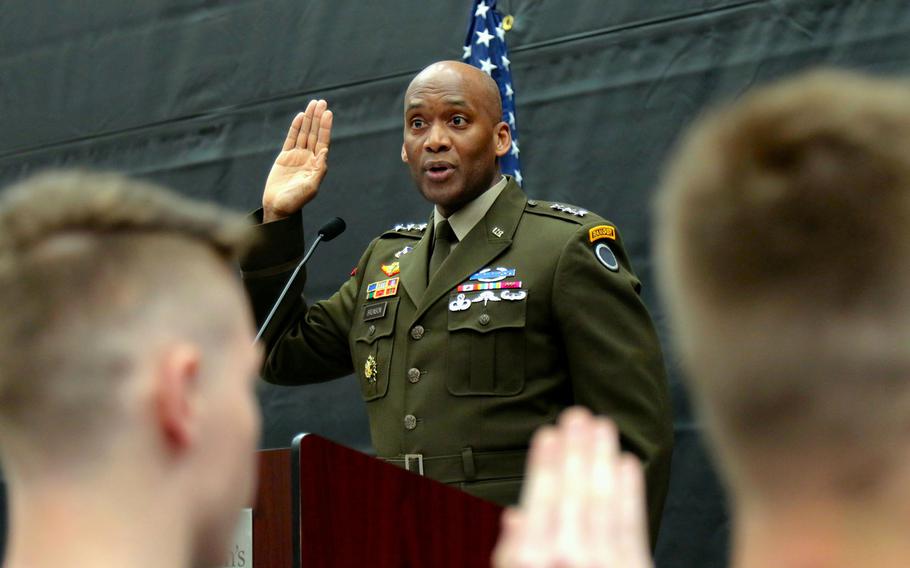 Army Lt. Gen. Xavier Brunson gives the oath of enlistment to recruits at Saint Martin University in Lacey, Wash., May 3, 2022.